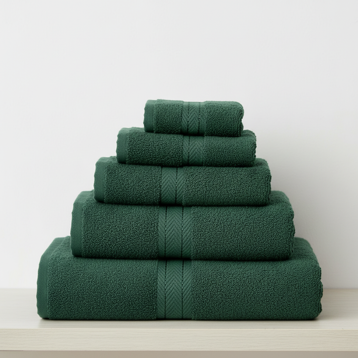 Close-up of a stack of folded white cotton bath towels, highlighting the plush texture and quality.