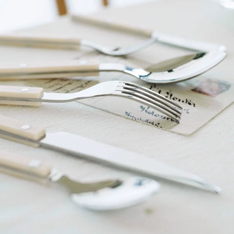 Sleek 24-piece stainless steel flatware with detailed engraving, designed for comfortable dining experiences.