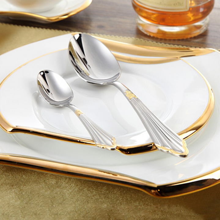 Gold stainless steel cutlery set beautifully arranged on a dining table, ideal luxury flatware for guests.