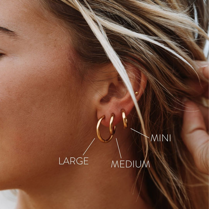 Close-up of a women's classic gold hoop earring, highlighting its smooth finish and elegant design.