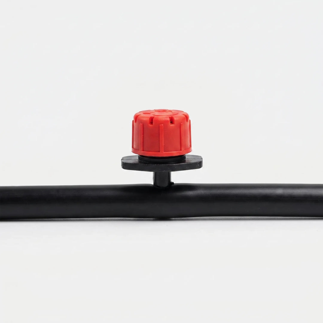 Close-up of an adjustable micro irrigation dripper, ideal for customizing water flow for garden plants.
