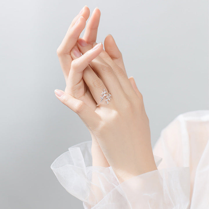 Close-up of a women's silver-toned adjustable leaf ring, featuring shimmering zirconia details.