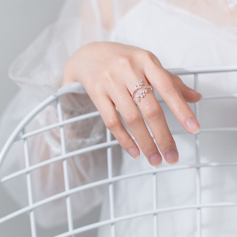 Nature-inspired women's adjustable ring with delicate leaves and brilliant zirconia for a versatile look.