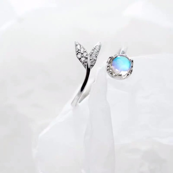 Elegant women's silver ring featuring an adjustable dolphin tail design & a dazzling blue zirconia.