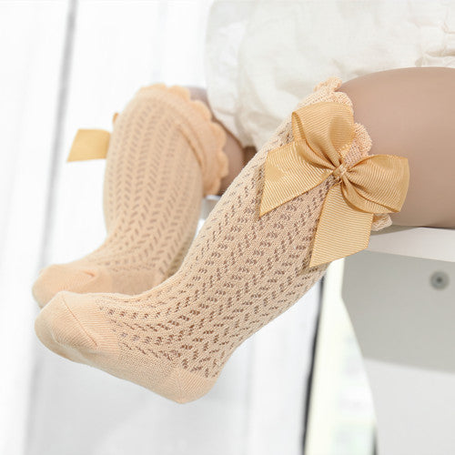Adorable pink baby cotton socks with large white satin bow, perfect for newborn girls and infant apparel, soft & comfortable.