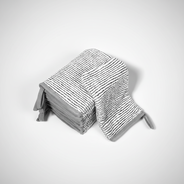 Six neatly stacked AquaJoy coral fleece wash mitts, emphasizing the set for skincare