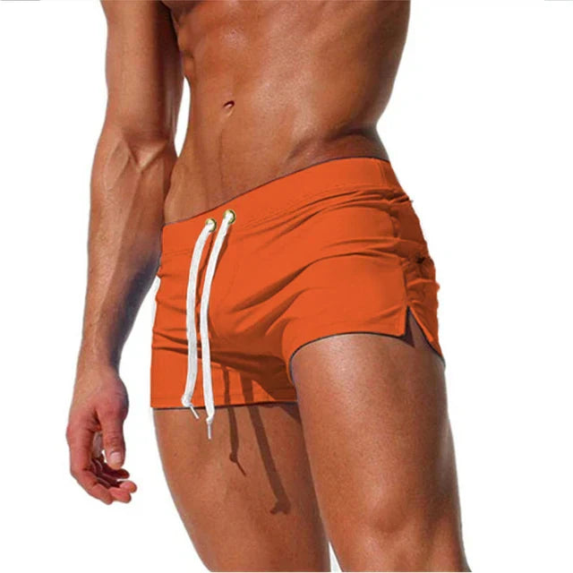 Model wearing Arlan men's quick-drying swim shorts on a beach, showcasing comfortable fit