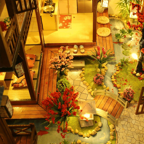 Completed large wooden dollhouse kit with tiny furniture & bright LED lights, a rewarding DIY miniature craft project.