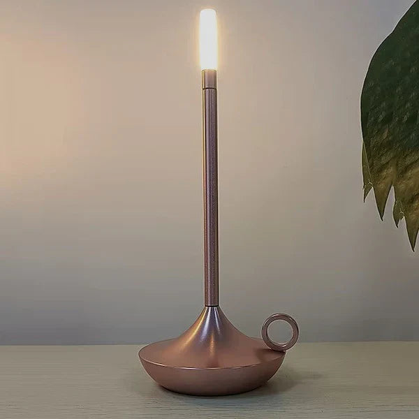 Modern Aurelia rechargeable lamp casting a warm, ambient light on a bedside table.