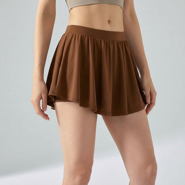 Dynamic shot of women's Ava sporty mini skirt in navy, highlighting its flexibility and built-in shorts.