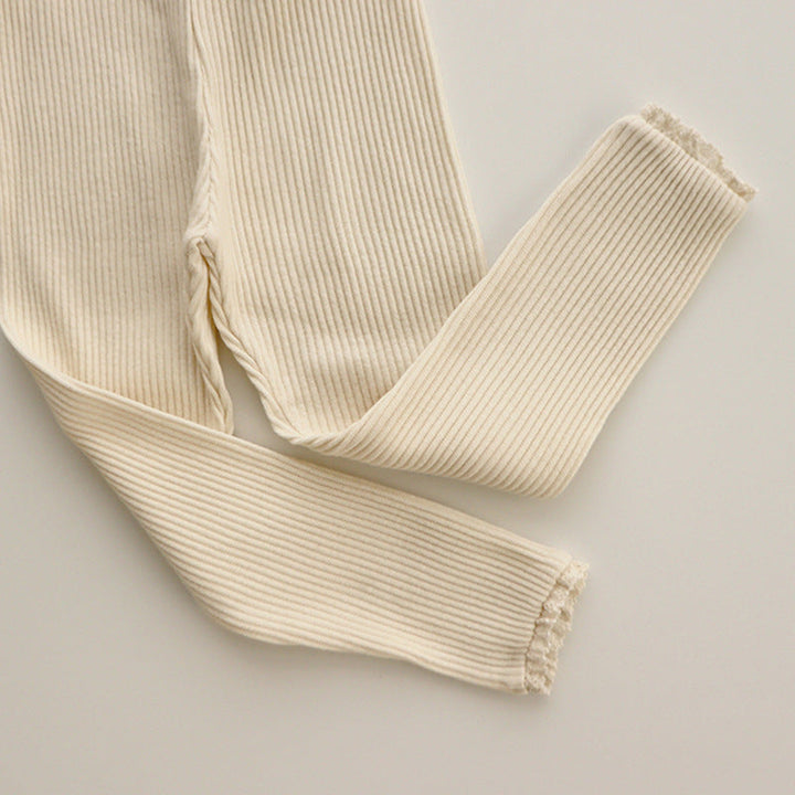 Close-up of ribbed baby leggings with intricate white lace trim for girls, showcasing the soft cotton knit and detailing