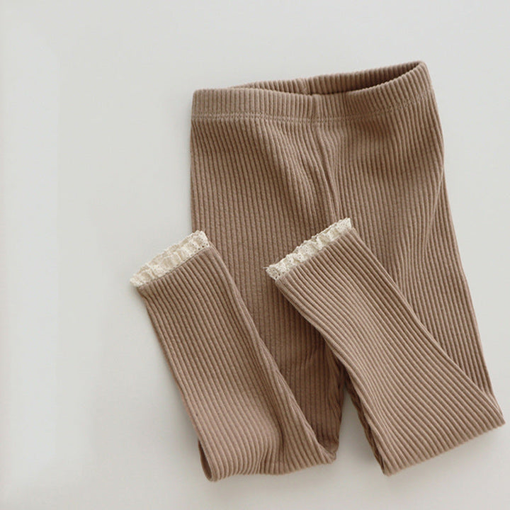 Folded light pink ribbed baby leggings with elegant lace trim, ideal as a baby girl gift, comfortable and stylish