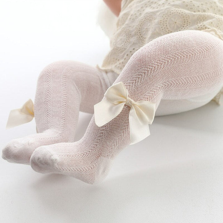 Comfortable baby girl's tights in a solid color with an ankle bow detail, ideal infant wear for spring and autumn outfits.