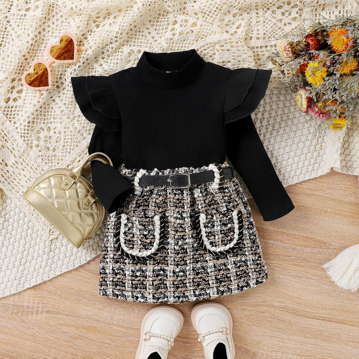 Baby girl modeling the pink knitted turtleneck and dress winter set, looking cozy and happy
