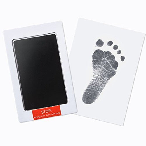 Newborn baby's tiny hand gently pressed onto the mess-free ink pad for a precious handprint.