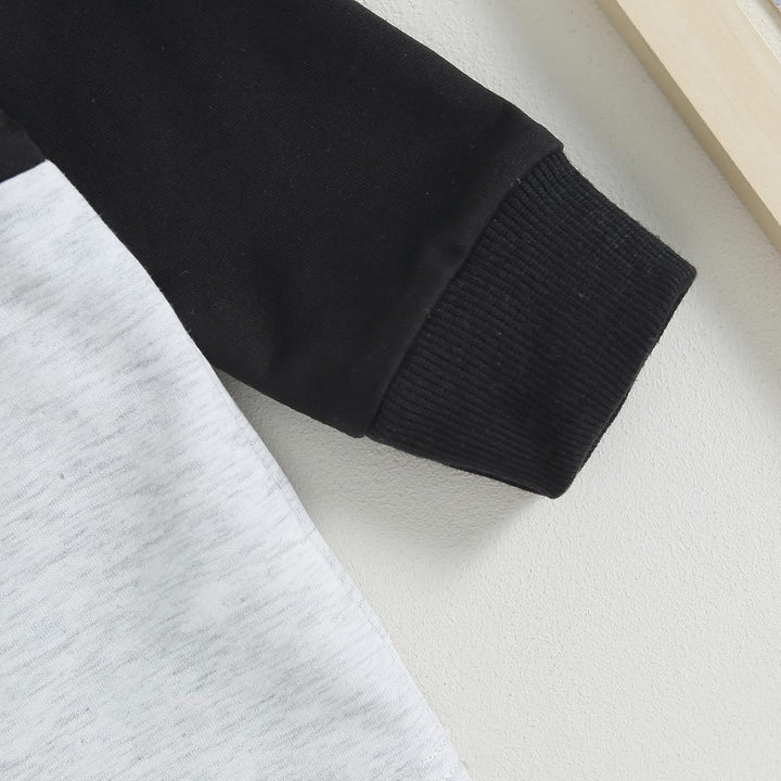 Baby jogger set, contrast sweatshirt emblem or logo, subtle brand detail.