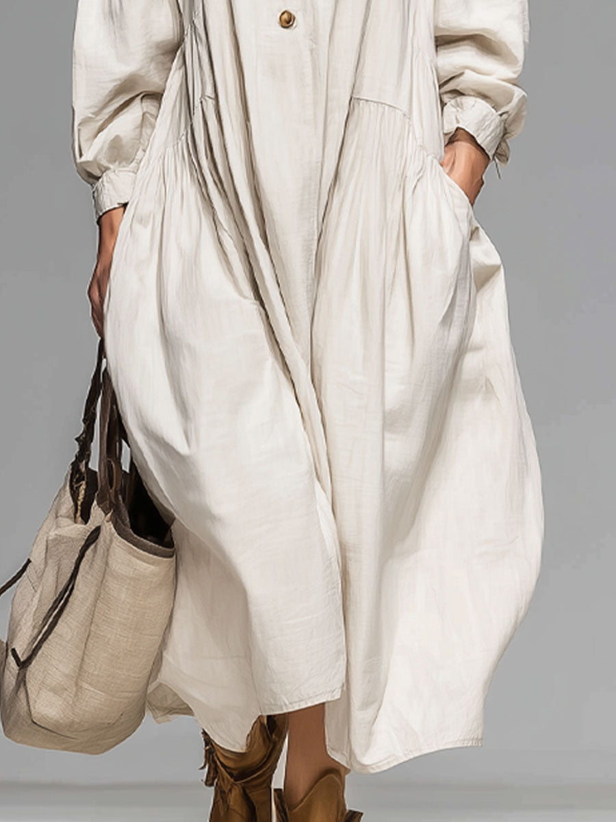 Comfortable loose midi dress for women featuring long sleeves, round neck, front buttons, and convenient pockets.