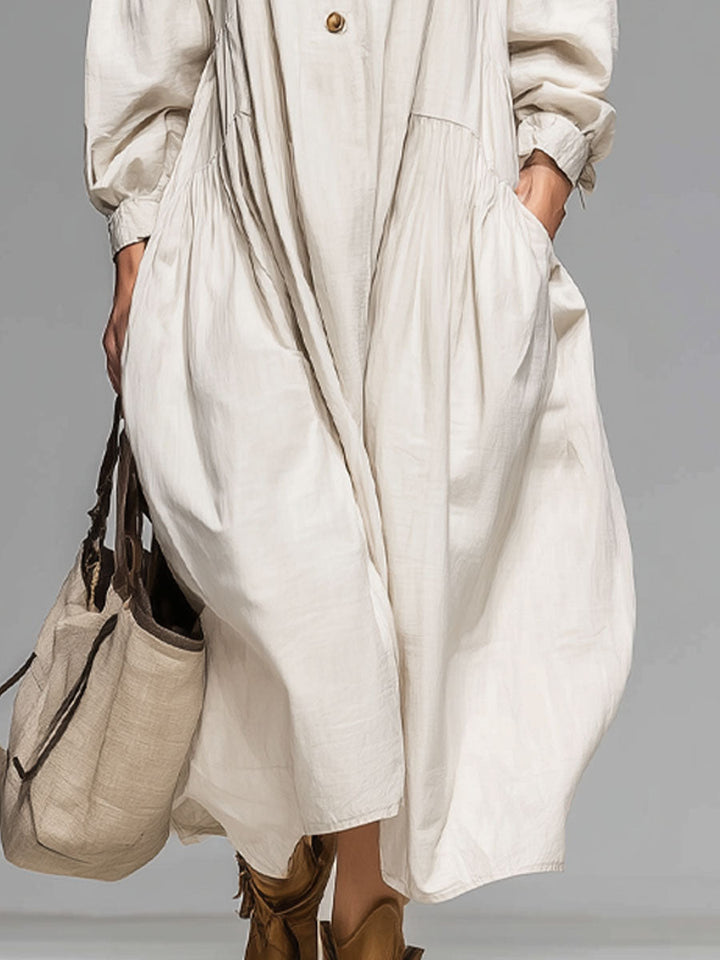 Comfortable loose midi dress for women featuring long sleeves, round neck, front buttons, and convenient pockets.