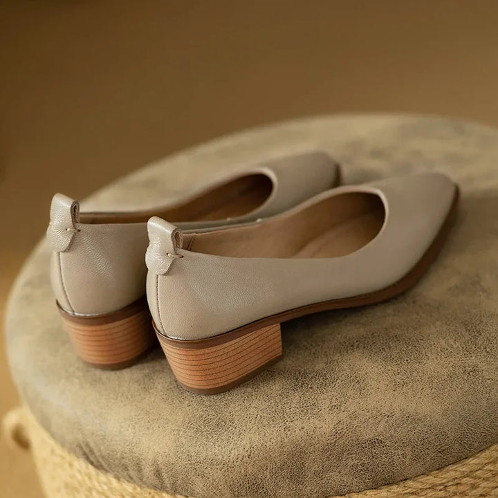 Sturdy block heel on women's beige slip-on court shoes, offering stability and comfort.