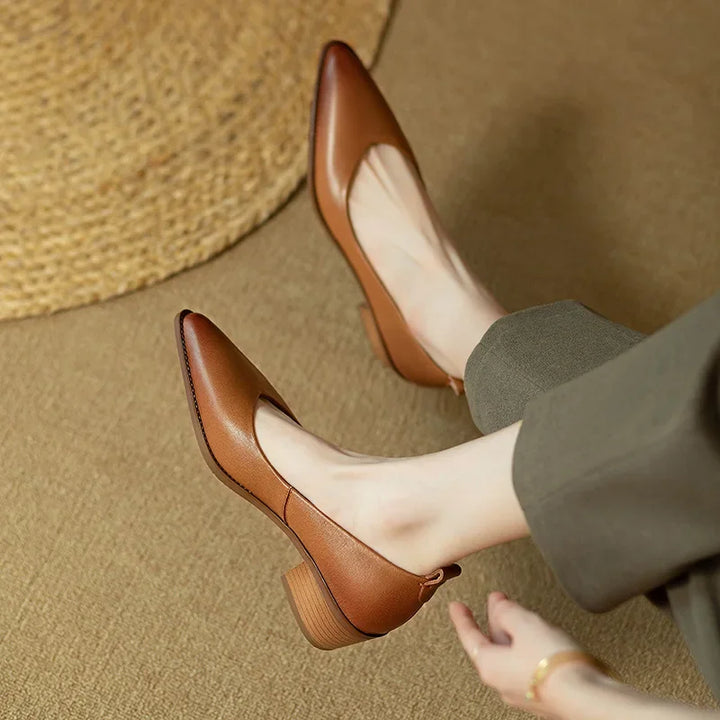 Woman wearing versatile beige pointed toe slip-on block heel court shoes for work.