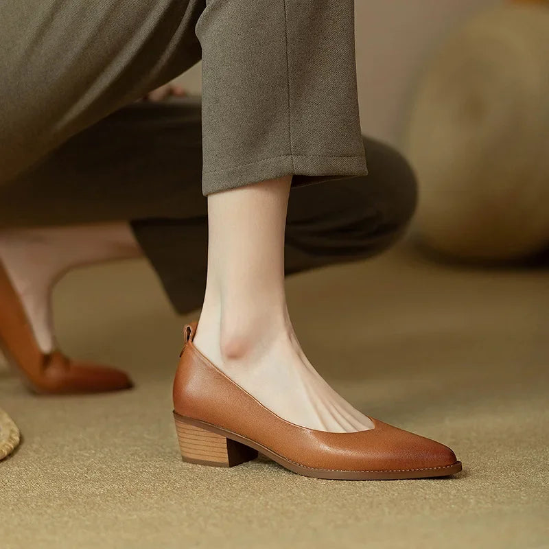 Professional woman's beige pointed toe block heel court shoes, elegant and comfortable.