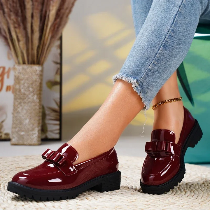 Comfortable women's slip-on loafers with chic bow detail. Versatile black chunky sole shoes for everyday style.