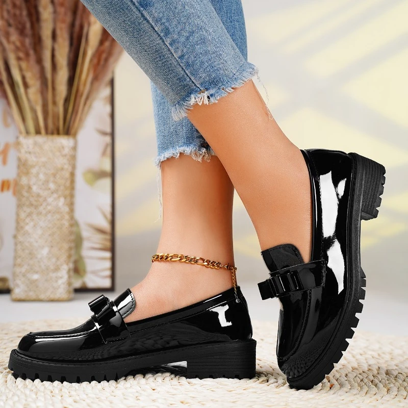 Elegant women's bow loafers in black. Stylish slip-on footwear with a comfortable chunky sole, perfect for fashion.