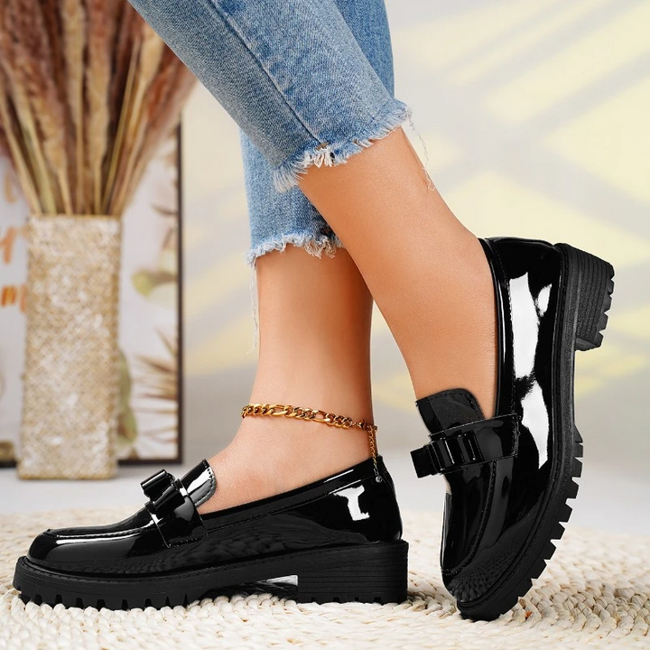 Elegant women's bow loafers in black. Stylish slip-on footwear with a comfortable chunky sole, perfect for fashion.