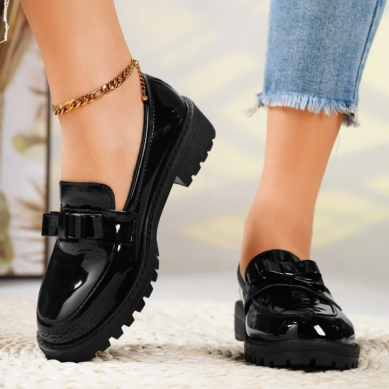 Stylish women's bow loafers with a comfortable chunky sole. Elegant black slip-on shoes, perfect for versatile fashion.