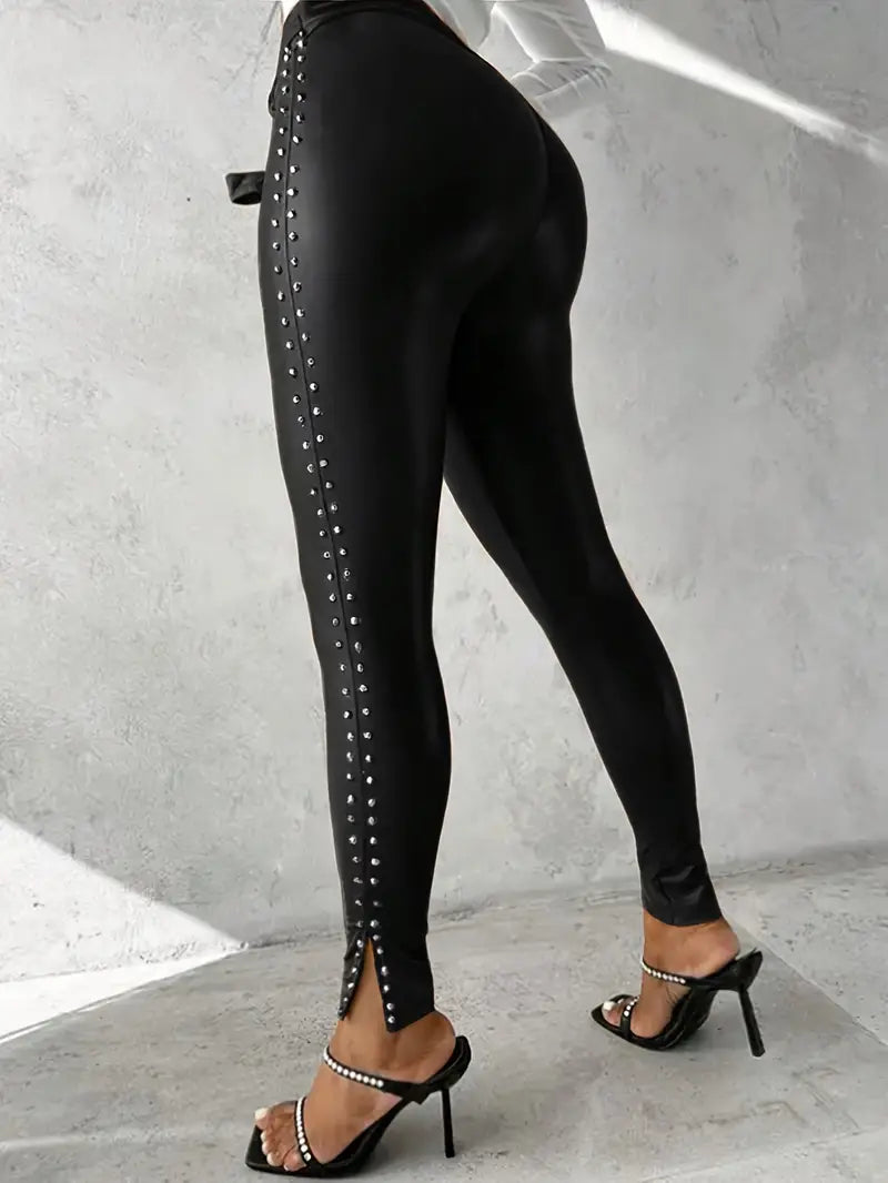 Model wearing black faux leather studded pants, showcasing slim fit & edgy style for women. High waist.
