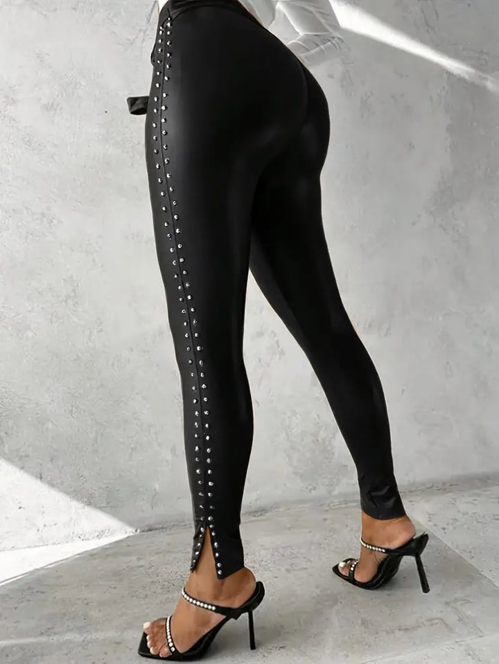 Model wearing black faux leather studded pants, showcasing slim fit & edgy style for women. High waist.