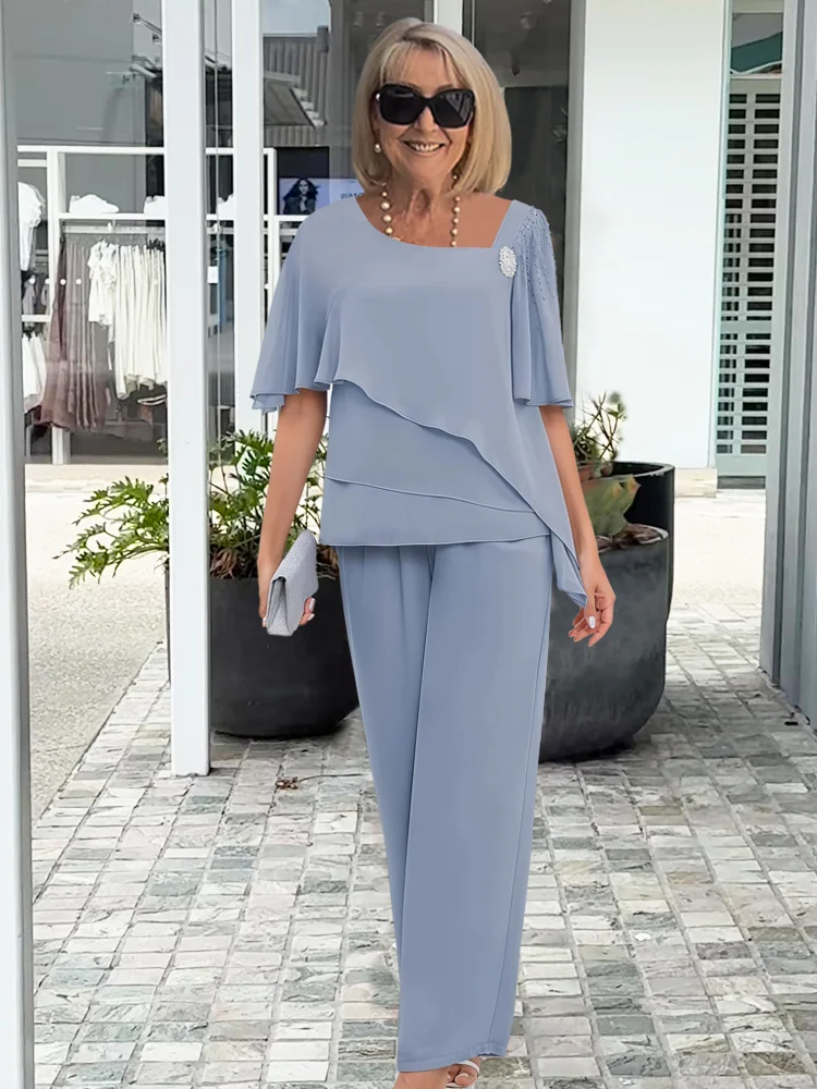 Blue women's graceful 2-piece set with elegant overlay top and straight-leg pants. Stylish, sophisticated fashion.