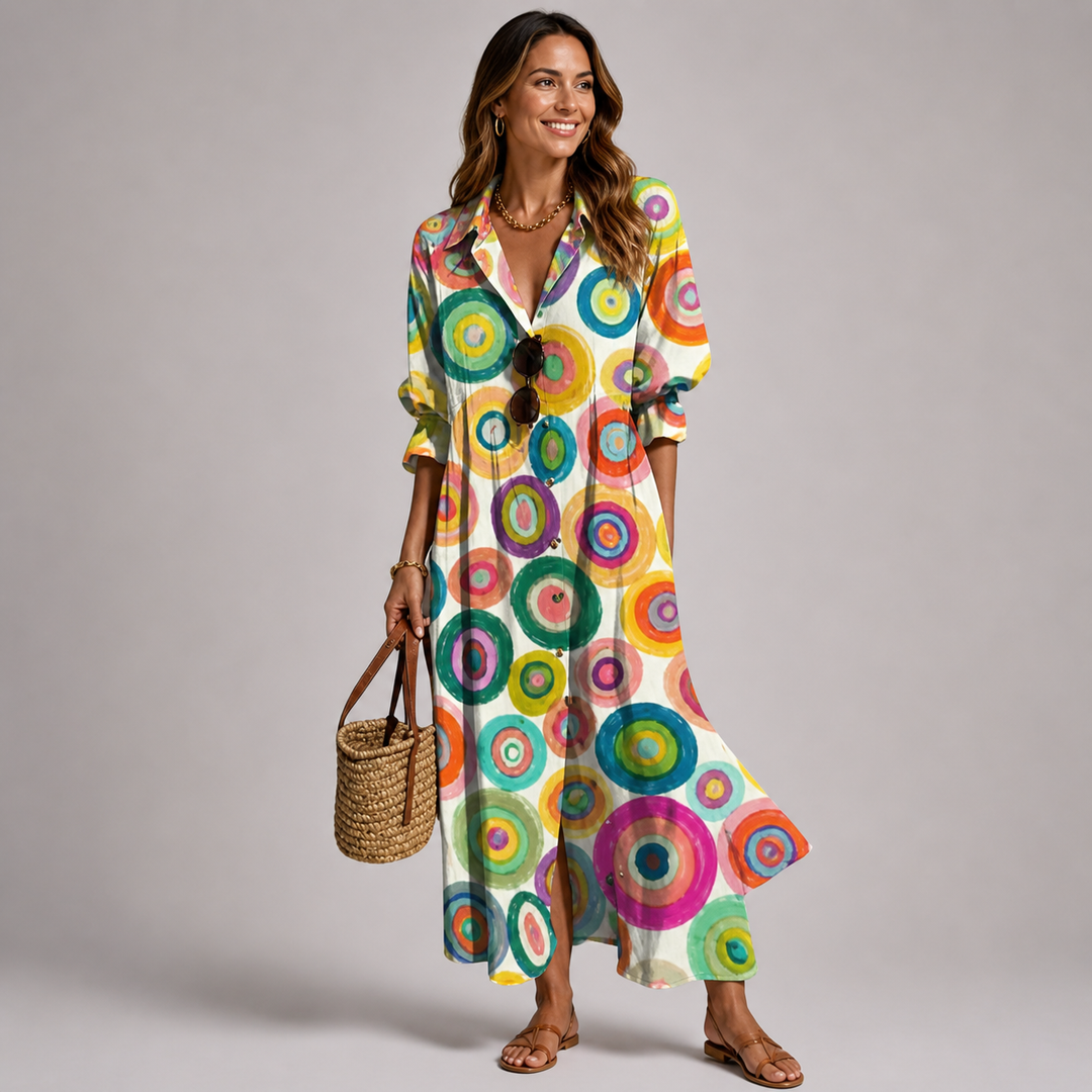 Woman wearing a flowy bohemian printed maxi dress with button front, V-neck, and long sleeves. Relaxed resort wear.