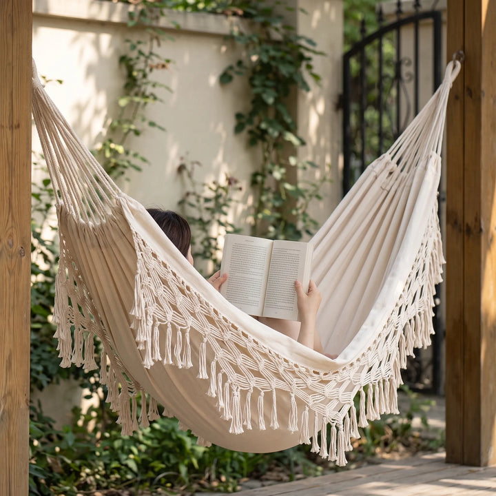 Close-up of the intricate tassels and woven cotton fabric of a bohemian outdoor hammock for garden relaxation.