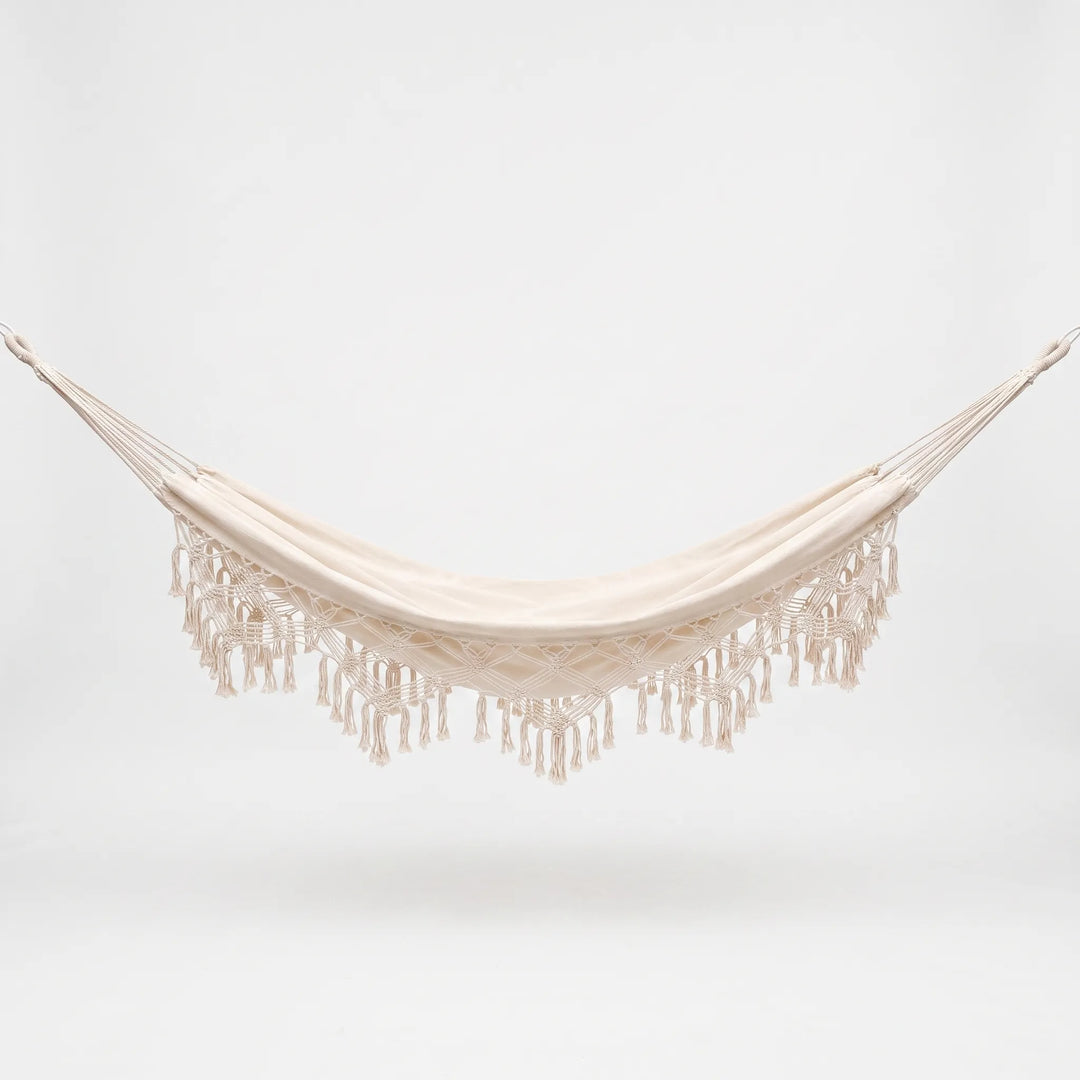 Stylish bohemian hanging hammock bed with decorative tassels, offering comfortable outdoor seating for garden use.