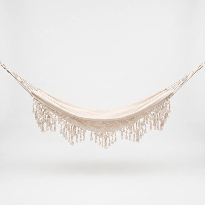 Stylish bohemian hanging hammock bed with decorative tassels, offering comfortable outdoor seating for garden use.