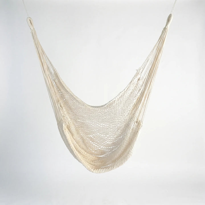 Full view of a sturdy boho tasseled outdoor hammock, a perfect hanging chair for sunbathing & garden serenity.
