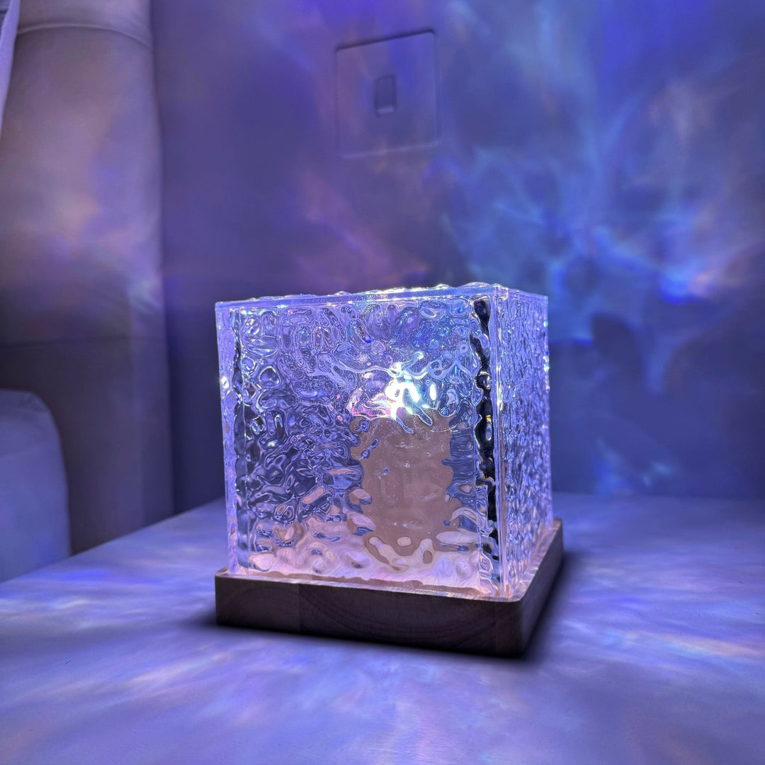 Hand holding the Borealis Cube, showing its portable and sleek cube light design