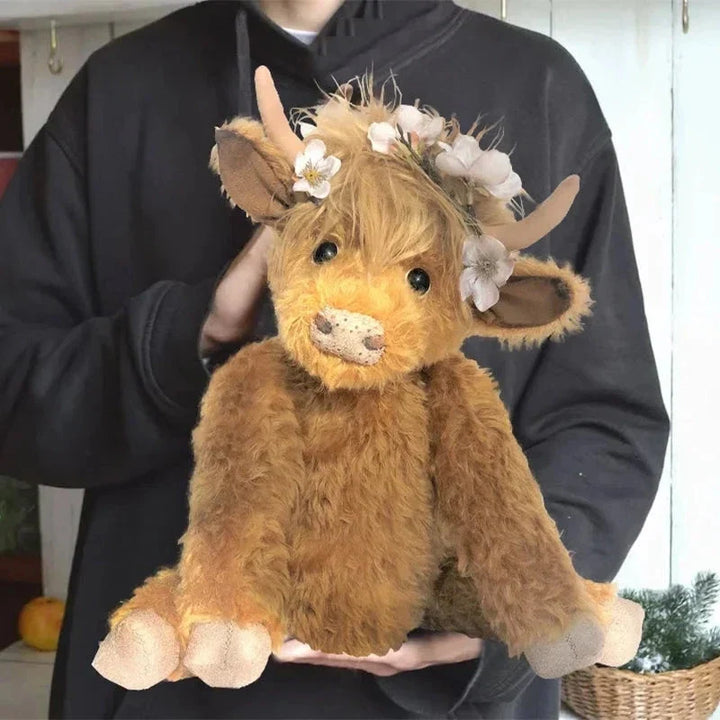 Cute Highland Cow plush wearing a colorful floral crown. This soft farm animal collectible makes lovely home decor.