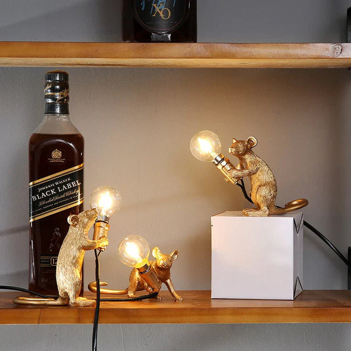 Close-up of a playful gold resin mouse LED table lamp, highlighting its intricate design and warm light.