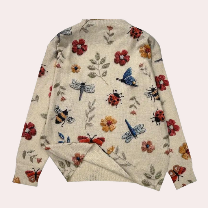 Elegant white women's sweater with vibrant floral print, comfortable and stylish for spring.