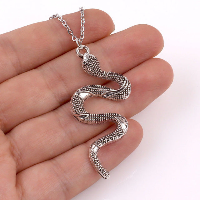 Silver-tone crystal serpent earrings, elegant women's accessory with a unique snake design.