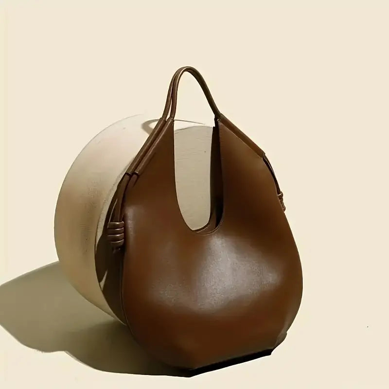 Front view of a chic obsidian oversized tote bag, minimalist design in durable vegan leather.