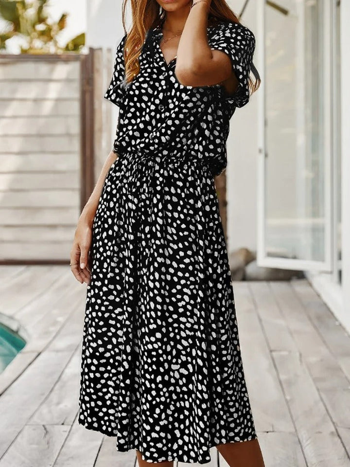 Angled view of women's chic printed summer midi dress, short sleeve, comfortable and fashionable.