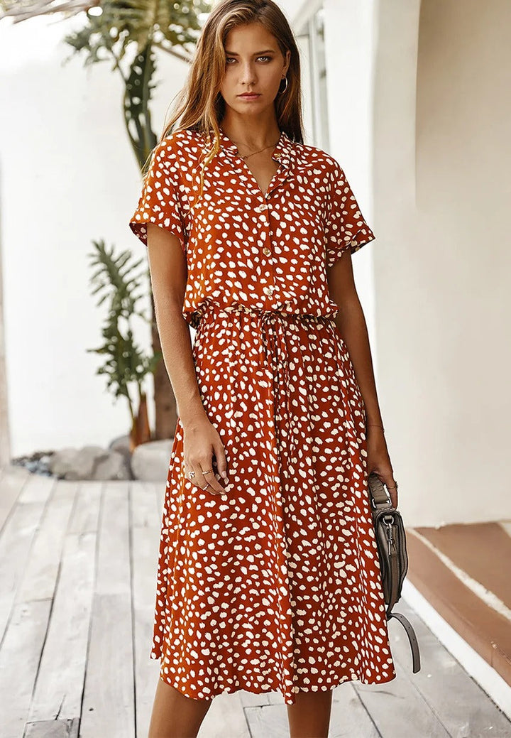 Close-up of women's chic printed midi summer dress fabric, short sleeves, comfortable fashion.