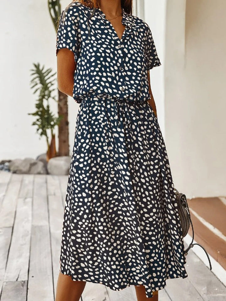 Woman wearing chic printed summer midi dress, short sleeves. Comfortable, versatile day dress.