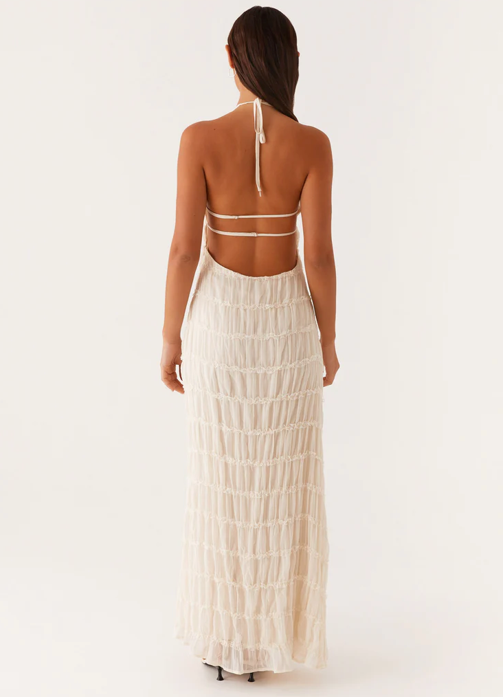Wedding guest maxi dress: elegant textured halter style with an open back, perfect for special events.