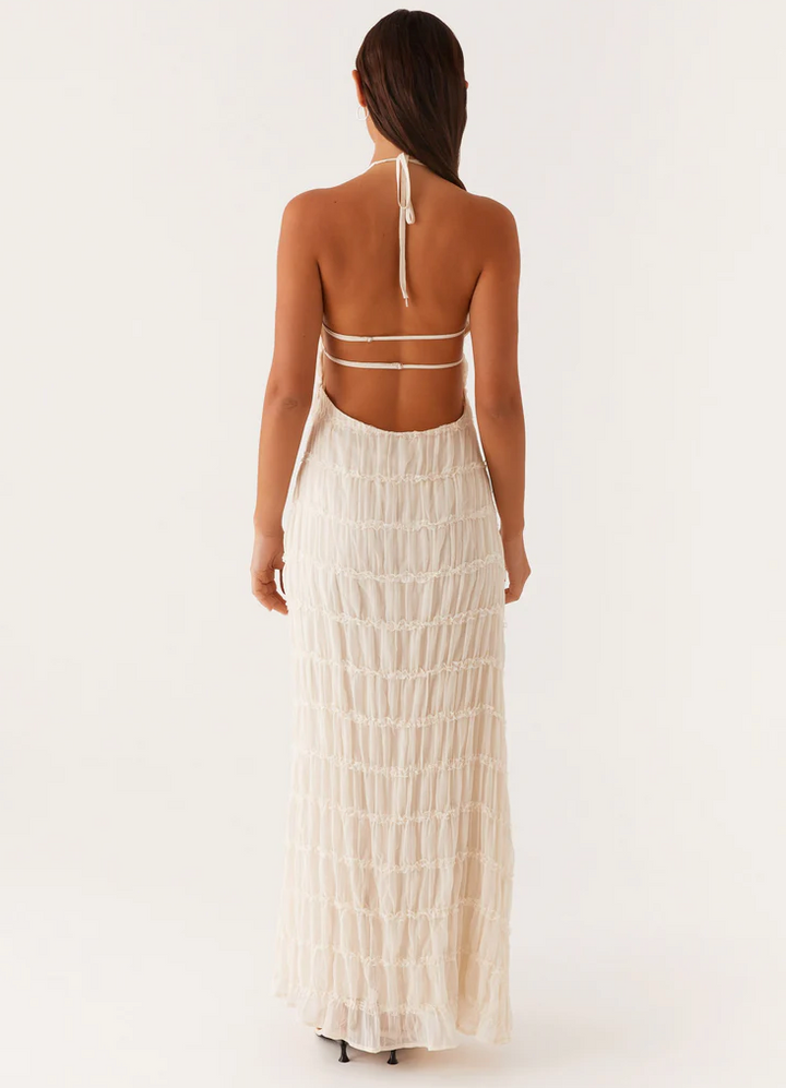 Wedding guest maxi dress: elegant textured halter style with an open back, perfect for special events.