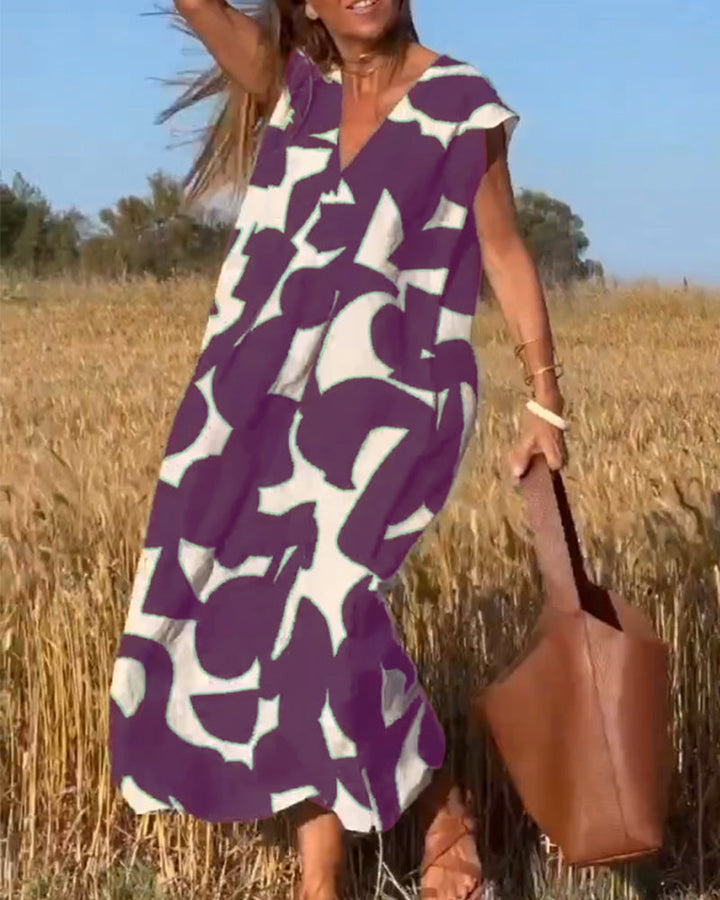 Detailed abstract print on a comfortable flowy women's summer day dress, with V-neck and cap sleeve.