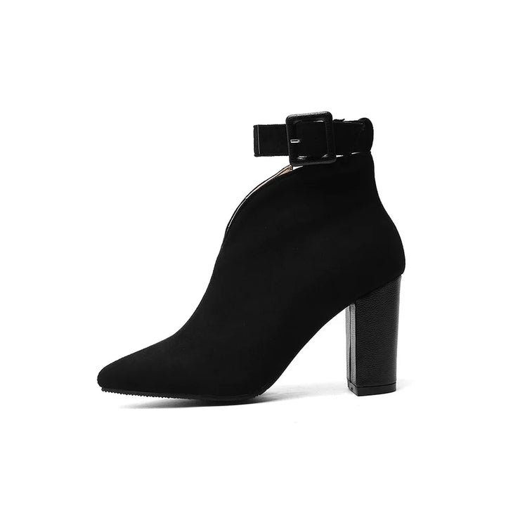Woman wearing chic buckle ankle boots with pointed toe & block heel, styled for day-to-night comfort.